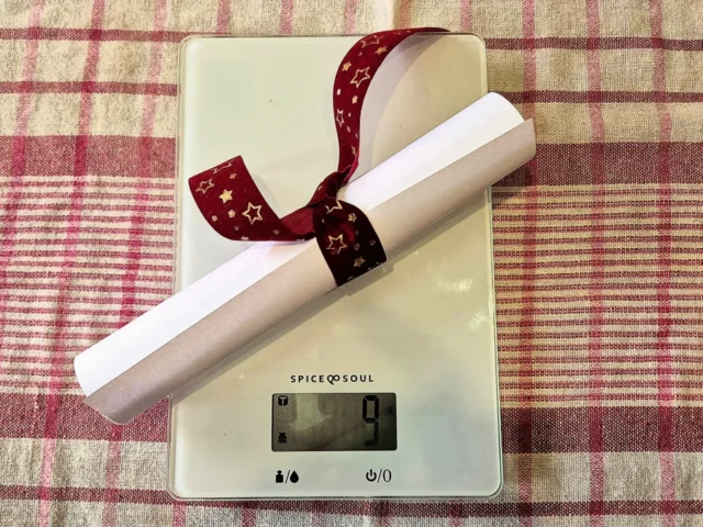 Prazan list papira za printanje umotan je u lijepu mašnu na kuhinjskoj vagi metafora je psihologije hrane bez kalorija.